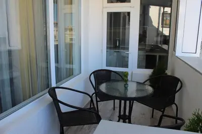 a balcony with a table and chairs on a porch at МЯСТОТО in Burgas City
