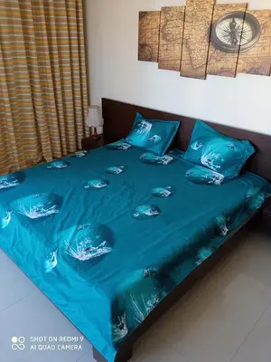 a bed with a blue blanket and pillows on it at Студио in Lozenets