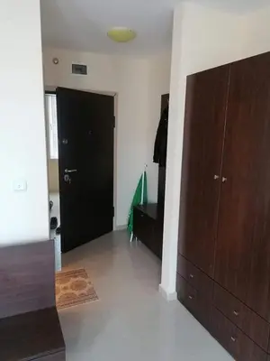 a living room with a black door and brown cabinets at Студио in Lozenets