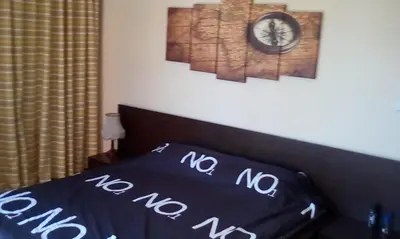 a bedroom with a bed and a clock on the wall at Студио in Lozenets