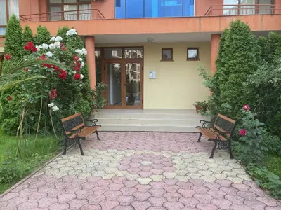 two chairs sitting in front of a house with flowers at ANITA B16 Studio Sunny Beach in Sunny Beach