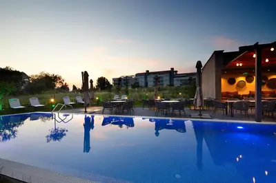 a swimming pool with tables and chairs and a building at Amara Sugar Hotel in Sunny Beach