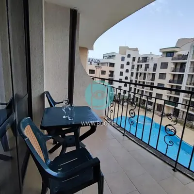 a balcony with a table and chairs and a pool at AVALON premium apartments in Sunny Beach