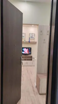 a room with a television and a hallway with a door at Апартамент Pink & Blue - 2BDR with Balcony - Wi-Fi in Varna City
