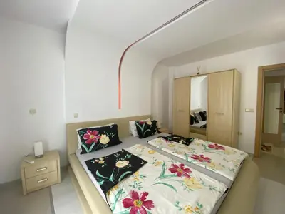 a bedroom with a large bed with flowers on it at VILLA ITTA 05 Apartment Sunny Beach in Sunny Beach