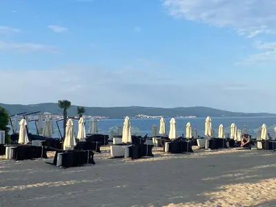 a group of tables and umbrellas on a beach at VILLA ITTA 05 Apartment Sunny Beach in Sunny Beach
