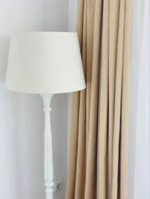 a lamp next to a curtain with a white shade at Hotel AVENUE in Ravda