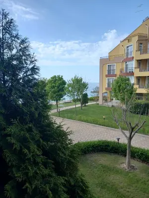 a building with a tree and a walkway at Студио Релакс, Ахелой in Aheloy
