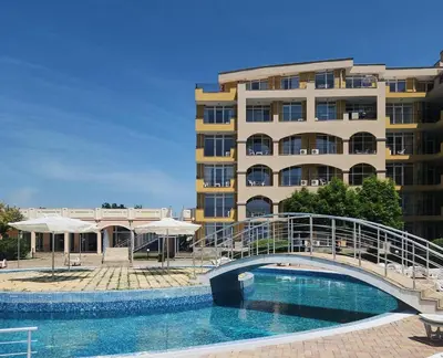 a bridge over a swimming pool in front of a building at Студио Релакс, Ахелой in Aheloy