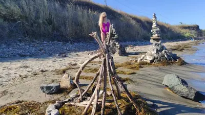 a woman standing next to a pile of drift wood at Студио Релакс, Ахелой in Aheloy