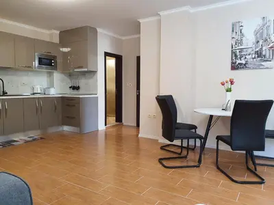 a kitchen with a table and chairs in a room at Апартамент За Гости ,,1В-15