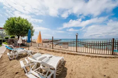 a group of chairs and umbrellas on a beach at Messambria Fort Beach - Premium Apartments in Elenite