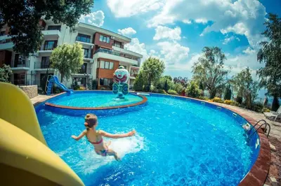 a young girl in a pool at a resort at Messambria Fort Beach - Premium Apartments in Elenite