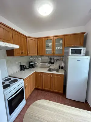 a kitchen with wooden cabinets and a white refrigerator at Messambria Fort Beach - Premium Apartments in Elenite