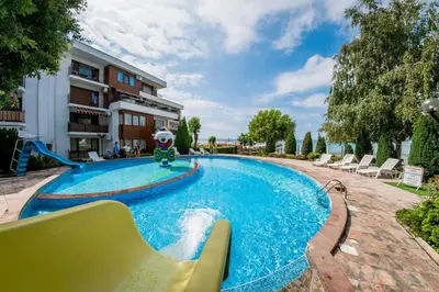 a large swimming pool with a slide in front of a building at Messambria Fort Beach - Premium Apartments in Elenite
