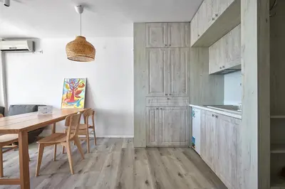 a kitchen with wooden cabinets and a table and chairs at 1BD Flat with a stunning SEA VIEW in Sozopol by Flаt Manаger in Sozopol
