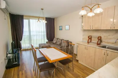 a kitchen and living room with a table and a couch at Guest apartments STELA in Tsarevo