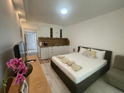 a small bedroom with a bed and a kitchen at Студио Симона 3 - първа линия море in Lozenets