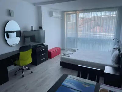 a bedroom with a bed and a desk and a mirror at Day Dream in Burgas City