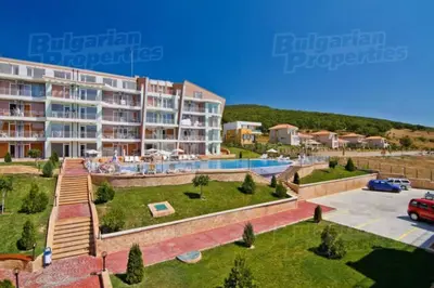 a large apartment building with a pool and a parking lot at Апартамент в Комплексе Сансет Кошарица,Солнечный берег in Kosharitsa
