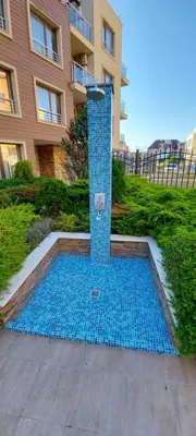 a swimming pool with a fountain in front of a building at Менада Хоризонт Апартаменти in Sozopol