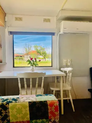 a dining room with a table and chairs and a window at Caravans 10 min to Tsonevo Lake & 35 min to Black Sea in Tsonevo