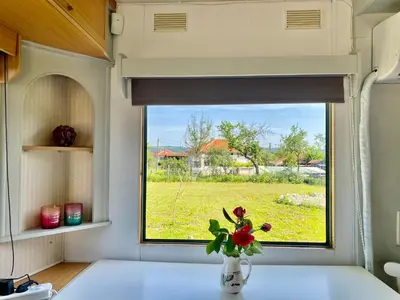 a window in a kitchen with a vase with flowers at Caravans 10 min to Tsonevo Lake & 35 min to Black Sea in Tsonevo