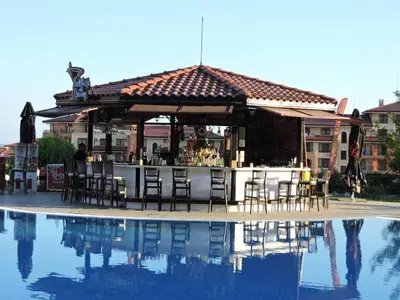 a bar with tables and chairs next to a pool at Magic Dreams Apart Complex Studio Sveti Vlas in Sveti Vlas