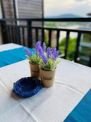 two purple flowers and a blue plate on a table at Santa Marina 2-bedroom apt. w/ Sea View + Terrace in Sozopol