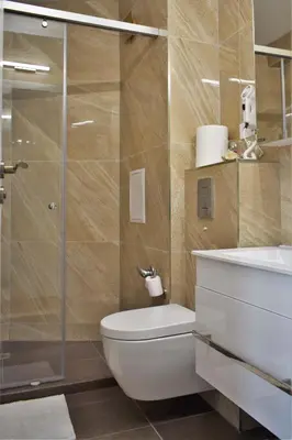 a bathroom with a toilet and a glass shower at Top center apartment Gramophone with private parking in Burgas City