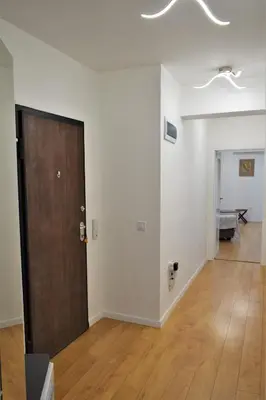 an empty room with a door and a wooden floor at Top center apartment Gramophone with private parking in Burgas City