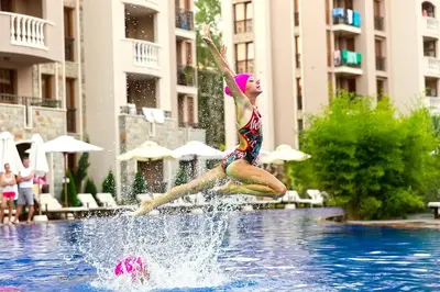 a young girl jumping into a swimming pool at Kalia, Zweizimmer, Zweibalkon, Top-Apartment in Sunny Beach
