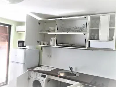a kitchen with a sink and a white refrigerator at Private apartments Stamopolu lux in Primorsko