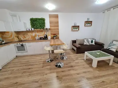 a living room with a couch and a kitchen at Little Treasure by the Sea in Pomorie