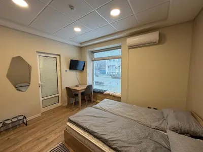 a bedroom with a bed and a desk and a window at Nõma studio in Varna City