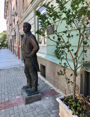 a statue of a man standing next to a building at Nõma studio in Varna City