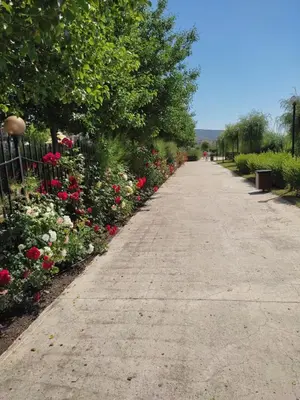 a long sidewalk with flowers and a fence at Prestige Fort Beach Private Apartment-Studio 46 in Sveti Vlas