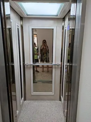 a woman taking a picture of a mirror in a hallway at Prestige Fort Beach Private Apartment-Studio 46 in Sveti Vlas