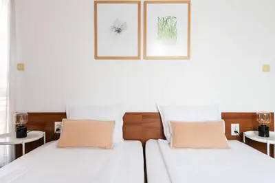 two beds in a bedroom with two pictures on the wall at Sea House Afrodita II in Nesebar