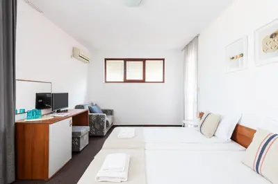 a white room with a bed and a desk at Sea House Afrodita II in Nesebar