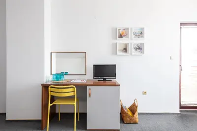 a desk with a computer and a yellow chair at Sea House Afrodita II in Nesebar