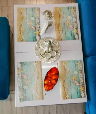 a table with a plate of eggs and fruit on it at Luxury Apartments Alix in Burgas City