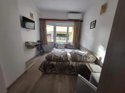 a bedroom with a bed and a television in it at Guest Rooms Kostovi in Nesebar