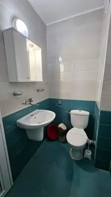 a bathroom with a white toilet and a sink at Guest Rooms Kostovi in Nesebar