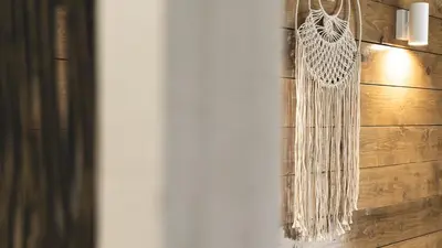 a white fringe curtain hanging on a wooden wall at La Finca - Saint Vlas in Sveti Vlas