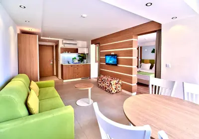 a living room with a green couch and a table at Hotel Forest Beach in Primorsko