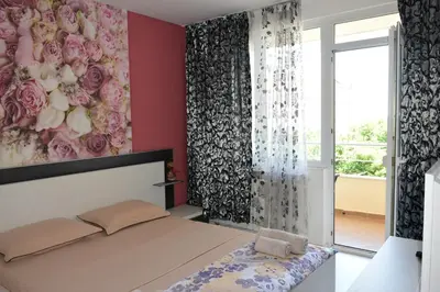 a bedroom with a bed and a painting of roses at dream apartment in Obzor