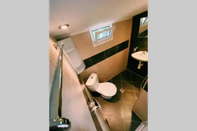 a bathroom with a toilet and a sink at Cute Little House with a White Picket Fence in Burgas City