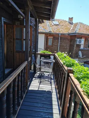 a wooden balcony with a table and chairs on it at The Old House in Nesebar