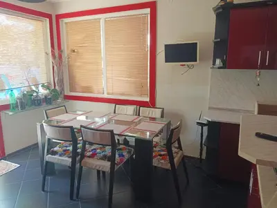 a dining room with a table and chairs and a window at Къща за гости Синьо Лято in Pomorie